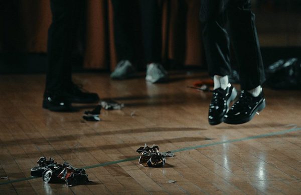 Image is a close up photo of dancers feet on a wooden floor.